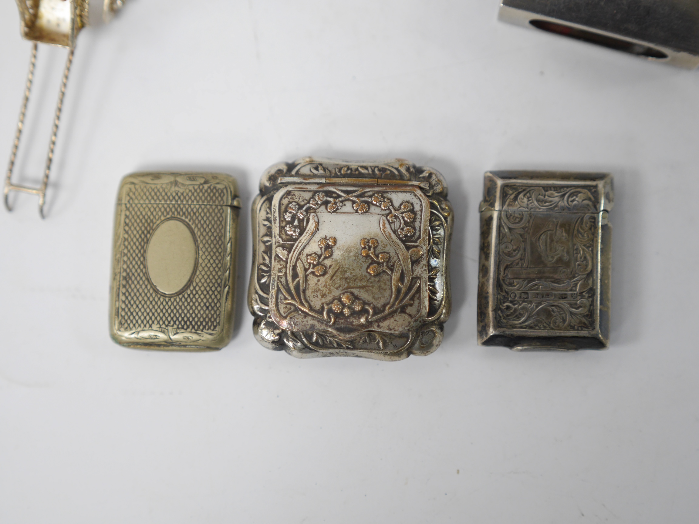 Assorted small collectables including a late Victorian silver vesta case, Birmingham, 1898, a small silver mounted circular photograph frame, a silver mounted glass pot and cover, a silver matchbox sleeve and three other